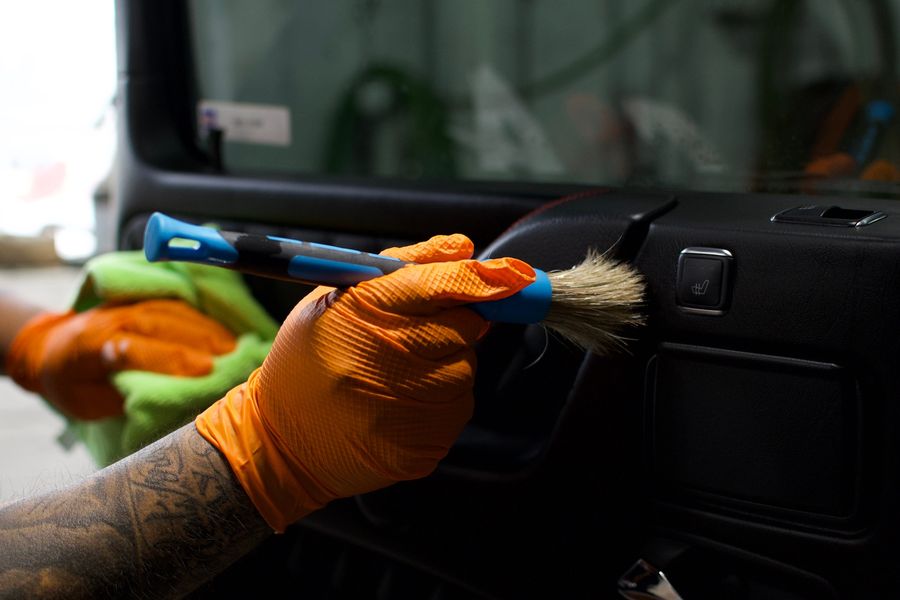 C & A Auto Body Shop detailing technician brushing a car interior panel